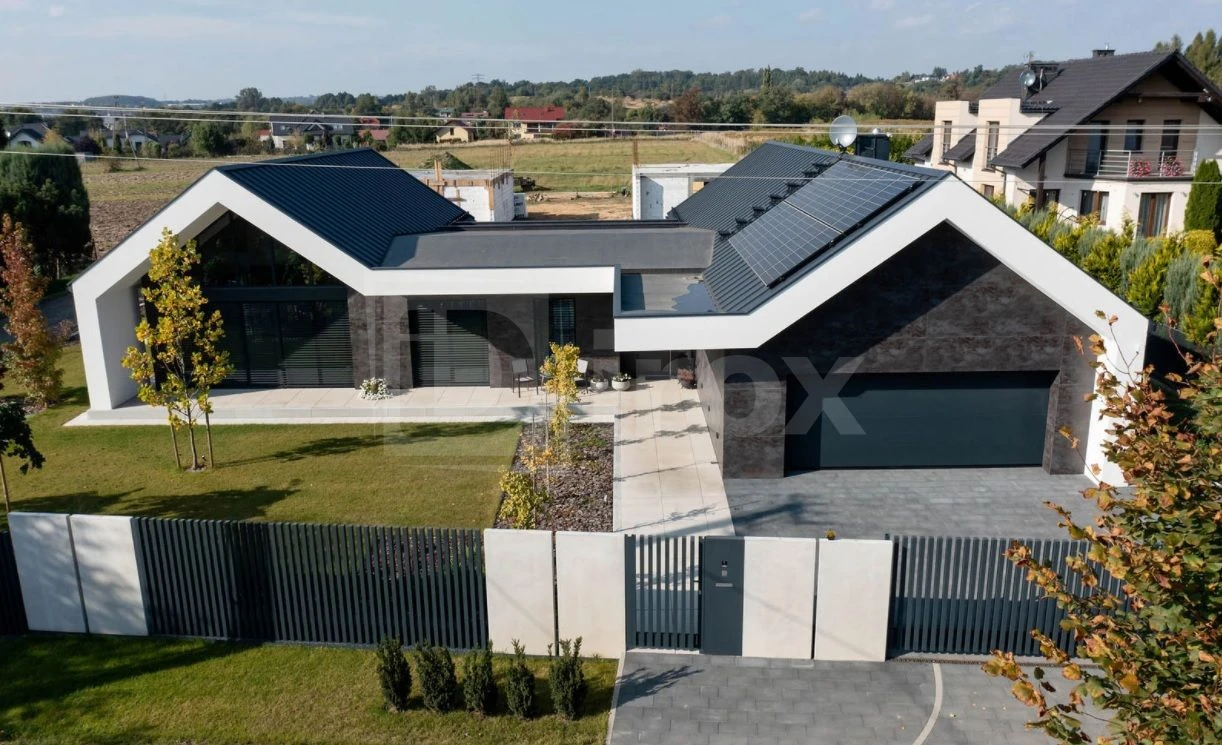 Nowoczesny dom z ogrodzeniem z betonu architektonicznego i metalowymi przęsłami